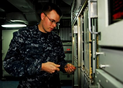 US Navy 101019-N-2218S-020 Fire Controlman 3rd Class Shane Nichlos performs maintenance on SPS-48E air search radar system aboard the amphibious as