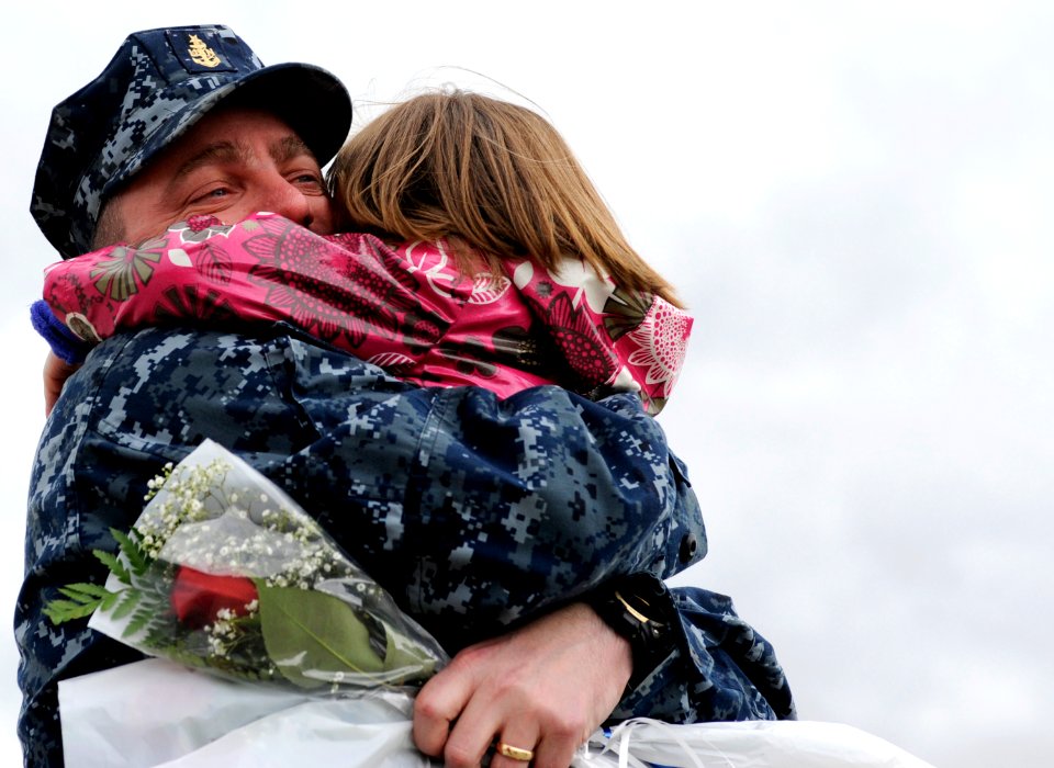 US Navy 101015-N-8467N-003 Senior Chief Fire Control Technician David Fennell hugs his three-year-old daughter during a homecoming celebration for