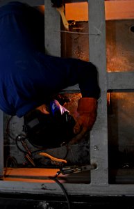US Navy 101018-N-5031T-156 Hull Maintenance Technician 2nd Class Matthew Kabisch, from Los Angeles, Calif., welds angle-irons on the flight deck ab