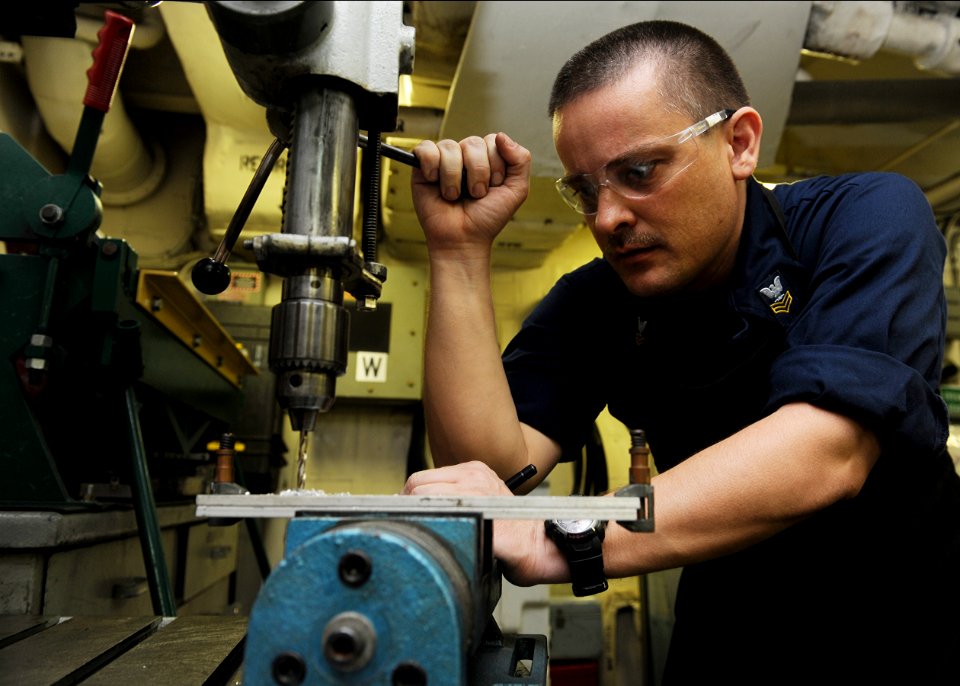 US Navy 101016-N-6427M-043 Aviation Structural Mechanic 1st Class James Lester, from Arkadelphia, Ark., drills a hole in metal plates for a T.V