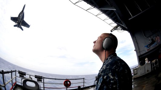 US Navy 101021-N-7103C-153 Seaman Kelcey Williams, from Augusta, Ga., stands the aft lookout watch as an F-A-18E Super Hornet lands aboard the airc