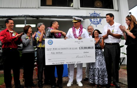 US Navy 101022-N-1906L-001 Rear Adm. Paul Bushong presents a ceremonial $50 million check to Lt. Gov. Michael Cruz