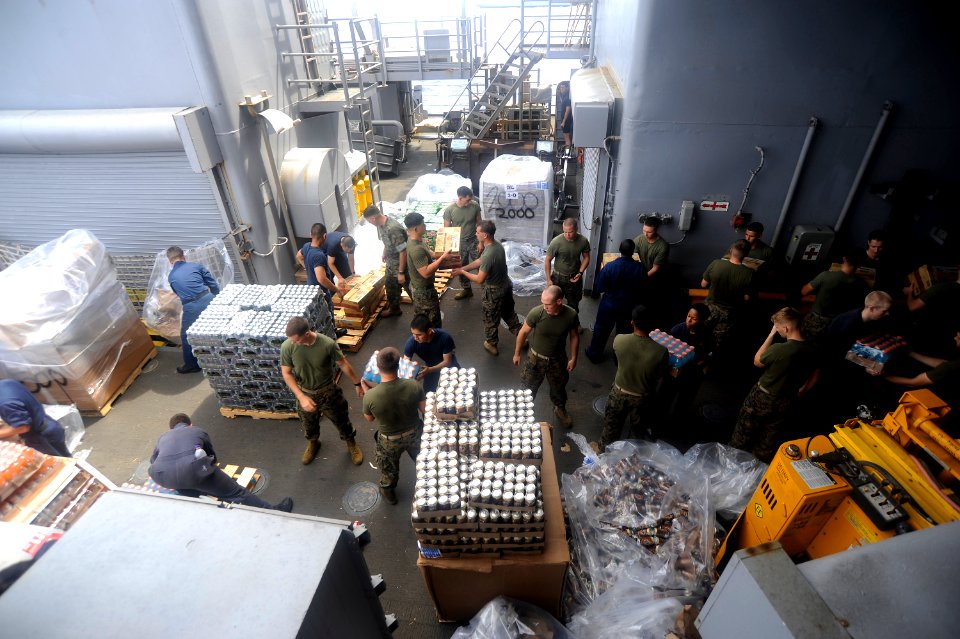 US Navy 101021-N-8335D-278 Sailors and Marines move stores aboard the amphibious dock landing ship USS Harpers Ferry (LSD 49) during a vertical rep