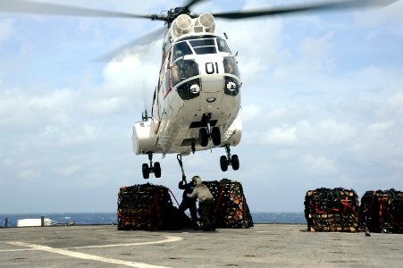 US Navy 101021-N-8335D-430 Service members hook a pole pendant to an SA-330j Puma helicopter during a vertical replenishment