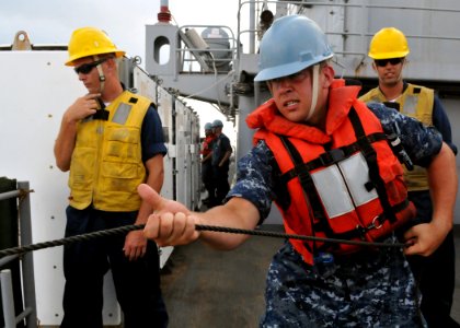 US Navy 101018-N-8113T-074 Seaman Nicholas Russell heaves in the phone and distance line aboard the amphibious transport dock ship USS Denver (LPD