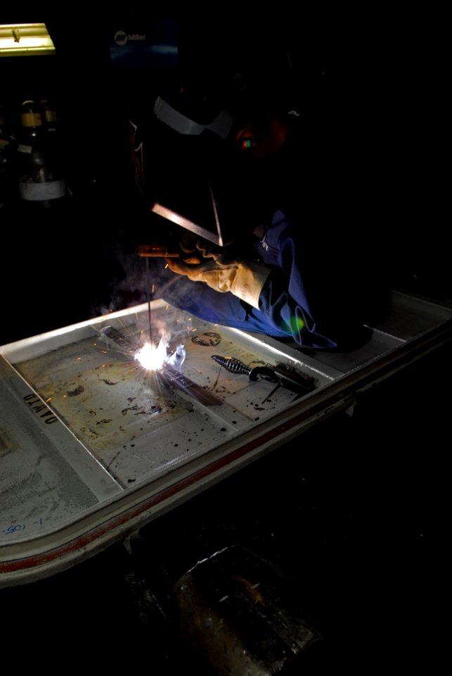 US Navy 101018-N-5031T-075 Hull Maintenance Technician fireman Jorge Ortiz, from Chicago, Ill., welds a hatch in the sheet metal shop aboard the Ni