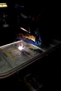 US Navy 101018-N-5031T-075 Hull Maintenance Technician fireman Jorge Ortiz, from Chicago, Ill., welds a hatch in the sheet metal shop aboard the Ni