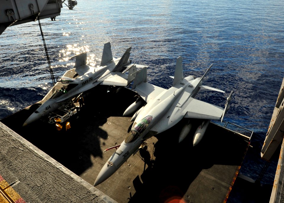 US Navy 101019-N-0569K-017 An F-A-18C Hornet, left and an F-A-18E Super Hornet are lowered on an aircraft elevator to the hangar bay of the aircraf