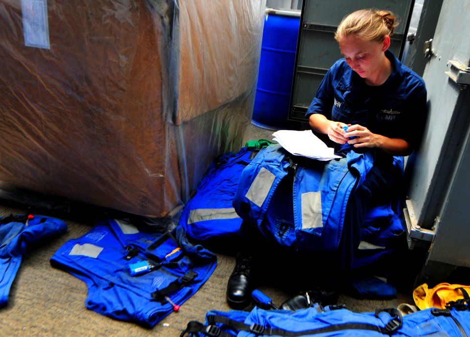 US Navy 101018-N-7948R-255 Logistics Specialist Seaman Amber Hahn takes inventory of float coats aboard the amphibious dock landing ship USS Pearl