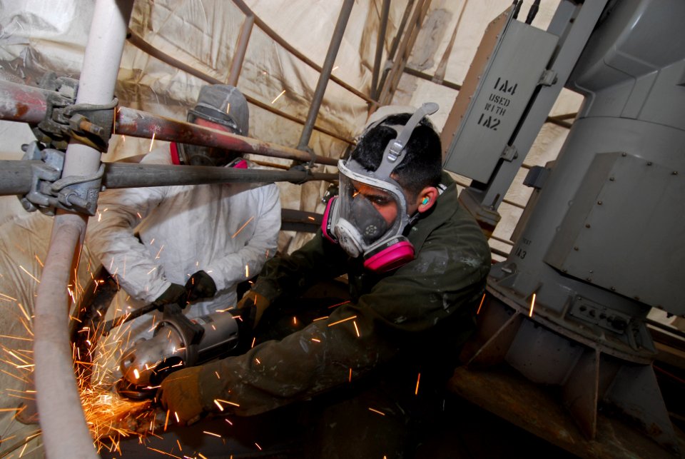US Navy 101019-N-5031T-036 Interior Communications Electrician 3rd Class Manuel Hollers, from Las Vegas, Nev., removes deck grating on the SMQ11 po