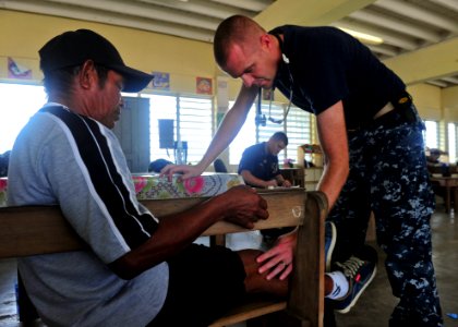 US Navy 101019-N-1531D-046 Lt. Cmdr. Ryan Fowler, embarked aboard the multi-purpose amphibious assault ship USS Iwo Jima (LHD 7), examines a man's