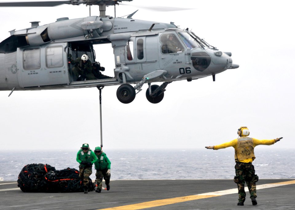 US Navy 101019-N-2013O-020 Sailors evacuate the drop area as a MH-60S Sea Hawk helicopter assigned to the Island Knights of Helicopter Combat Suppo