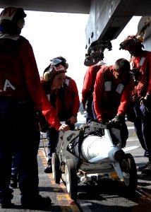 US Navy 101020-N-4973M-111 Aviation ordnancemen prepare to load a Joint Direct Attack Munition (JDAM) bomb onto an F-A-18C Hornet