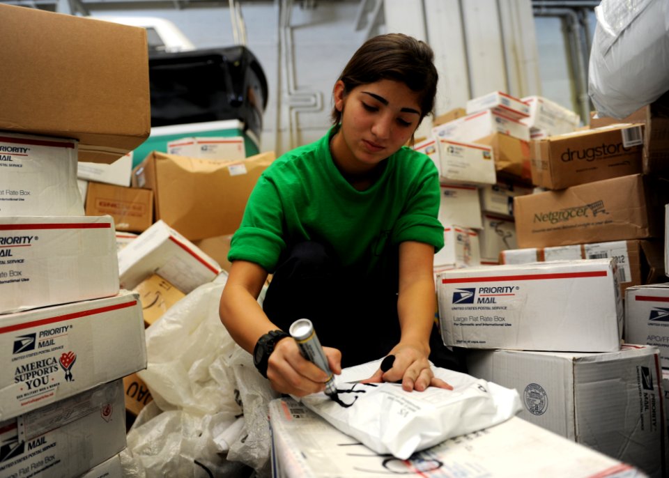 US Navy 101019-N-6427M-053 Logistics Specialist Seaman Recruit Ashley Winters, from San Antonio, Texas, writes mail box numbers on packages to ensu