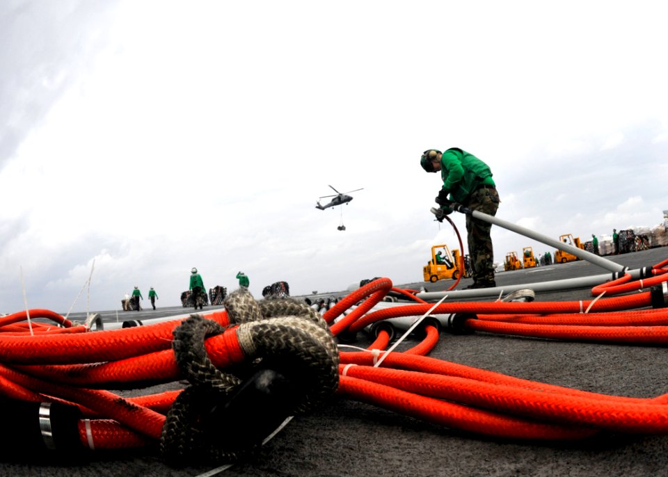 US Navy 101019-N-7103C-048 Logistics Specialist 3rd Class Lui Sin secures several pole pendants together on the flight deck of the aircraft carrier