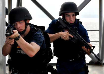 US Navy 101020-N-3620B-035 Culinary Specialist 3rd Class Christopher Plowden, left, and Logistics Specialist Seaman David Mangum take positions dur