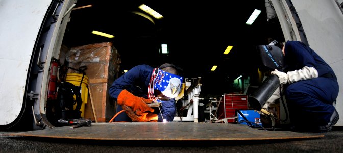 US Navy 101021-N-7103C-167 Sailors weld a ramp on the fantail of the aircraft carrier USS George Washington (CVN 73)