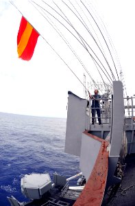 US Navy 101020-N-7103C-055 Quartermaster Seaman Takarah Cherrington, from Miami, lowers a signal flag on the signal bridge of the aircraft carrier