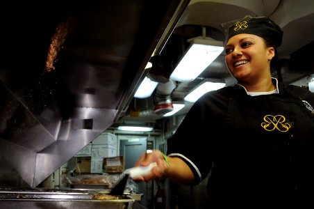 US Navy 101020-N-9132C-092 Culinary Specialist Seaman Apprentice Christina Clayton, from Atlanta, prepares hamburgers for officers in the wardroom