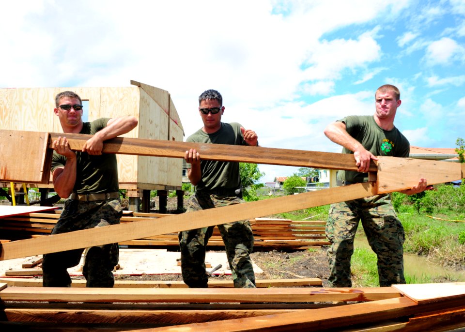 US Navy 101023-N-1531D-018 Marines assigned to Special Purpose, Marine Air Ground Task Force lift roof framing for a storage building during a Cont