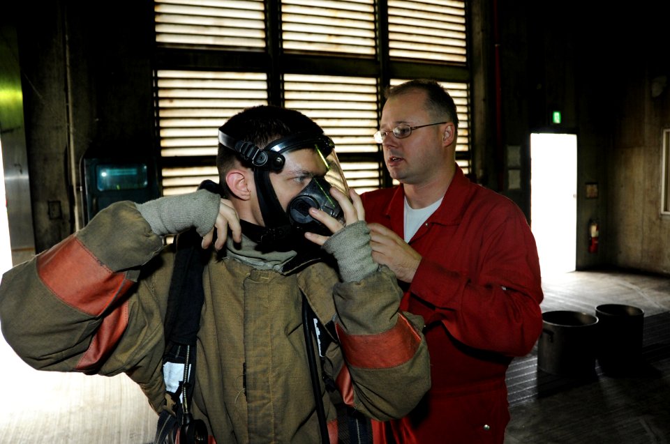 US Navy 101026-N-8421M-026 Damage Controlman 1st class Steven Zezulka, right, helps Electrician's Mate 2nd Class Adam Henley with his firefighting