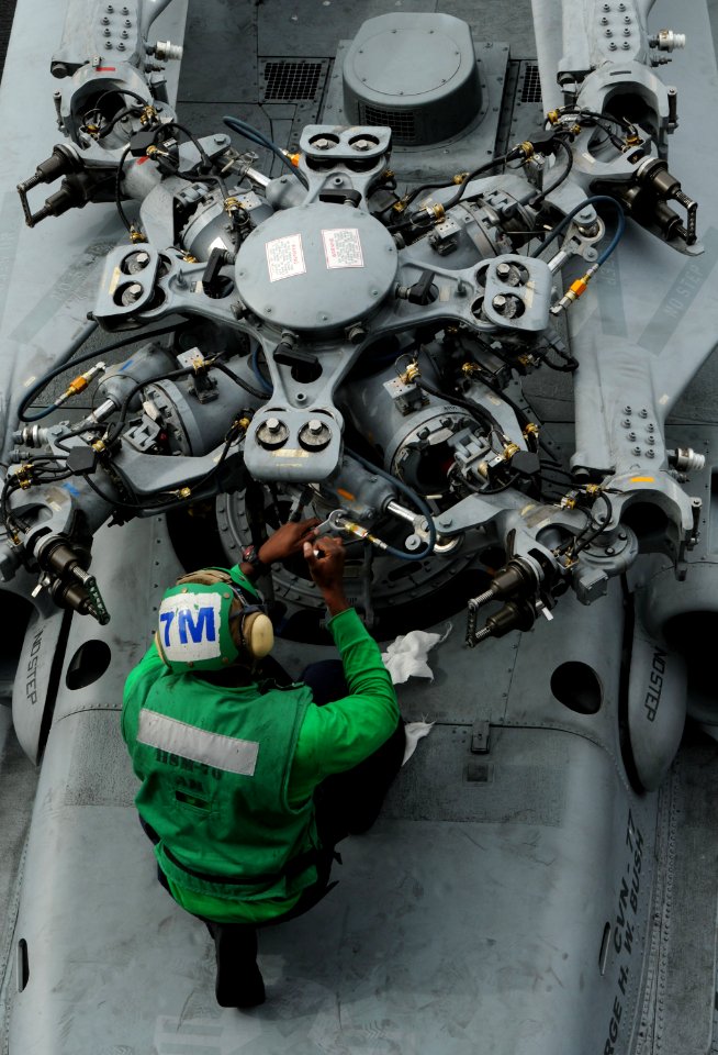 US Navy 101025-N-8560K-047 A Sailor assigned to Helicopter Maritime Attack Squadron (HSM) 70 performs maintenance on an MH-60R Sea Hawk helicopter