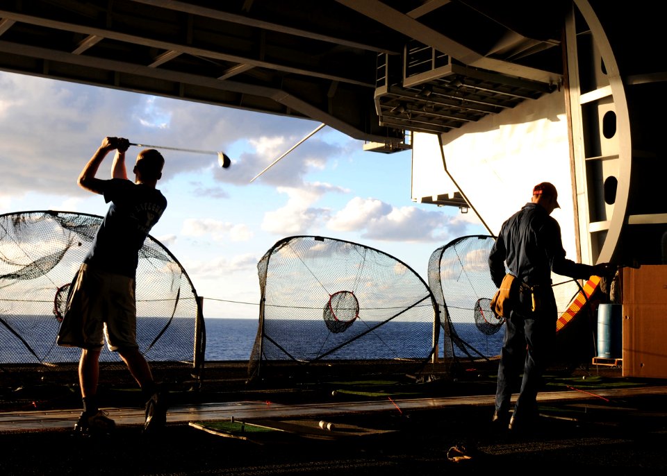 US Navy 101024-N-3737T-142 ailors aboard the aircraft carrier USS George H.W. Bush (CVN 77) hit golf balls in the ship's hangar bay during a morale