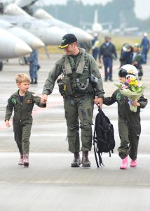 US Navy 101026-N-2858S-206 Cmdr. William Gotten, executive officer of the Dambusters of Strike Fighter Squadron (VFA) 195, walks with his son and d