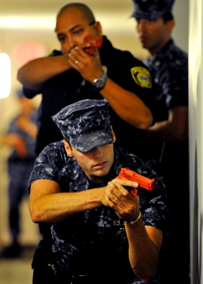 US Navy 101028-N-2055M-340 Master-at-Arms Seaman Jon Finley posts himself and his team outside a door at the Pacific Beacon housing complex at Nava