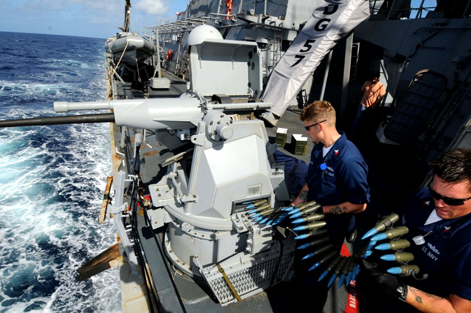 US Navy 101026-N-1854W-247 Gunner's Mate 1st Class Mike Rehfuss and Gunner's Mate 1st Class Omar Elhoss load the MK-38 25mm chain gun aboard the gu