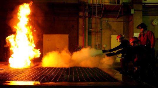 US Navy 101026-N-8421M-004 Sailors assigned to the attack submarine USS Buffalo (SSN 715) extinguish a fire during continual firefighting training