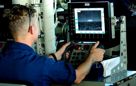 US Navy 101026-N-8913A-991 Gunner's Mate 1st Class Omar Elhoss prepares to remotely fire one of the MK-38 25mm chain guns aboard the guided-missile