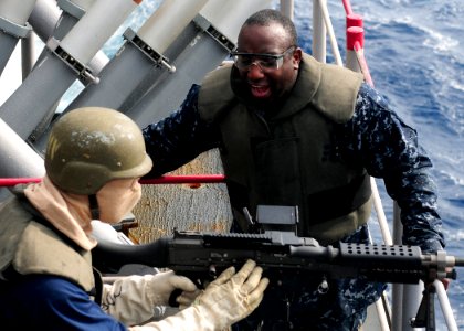 US Navy 101028-N-5538K-110 Aviation Ordnanceman 1st Class Justin L. McCray, right, instructs Aviation Ordnance Airman Eric C. Bell on the correct u