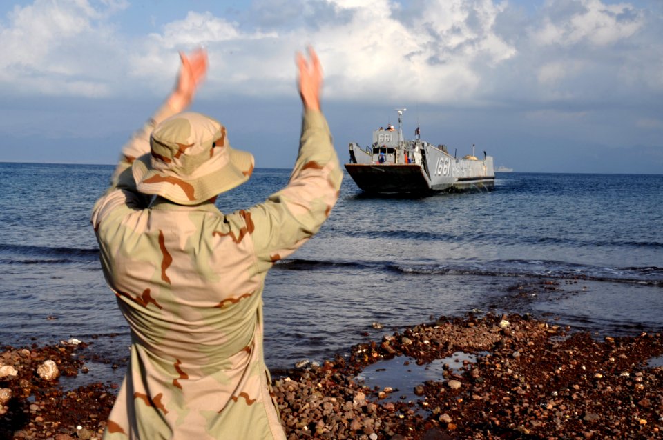 US Navy 101029-N-7293M-401 Seaman Kevin Rovito, assigned to Beachmaster Unit (BMU) 2, guides Landing Craft Utility 1661, assigned to Assault Craft