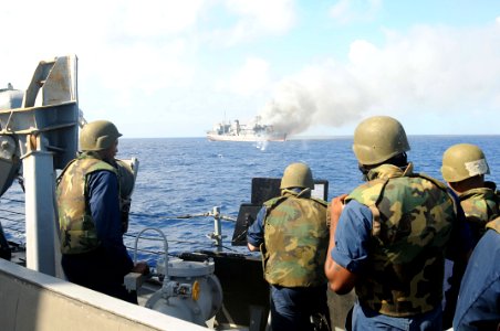 US Navy 101027-N-1854W-179 ailors aboard the guided-missile destroyer USS Mitscher (DDG 57) fire a .50-caliber machine gun at the ex-USNS Saturn du