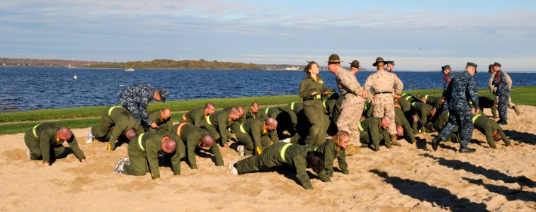 US Navy 101029-N-8848T-129 Officer candidates perform calisthenics in the sand along Narragansett Bay during the first week of the 12-week Officer photo