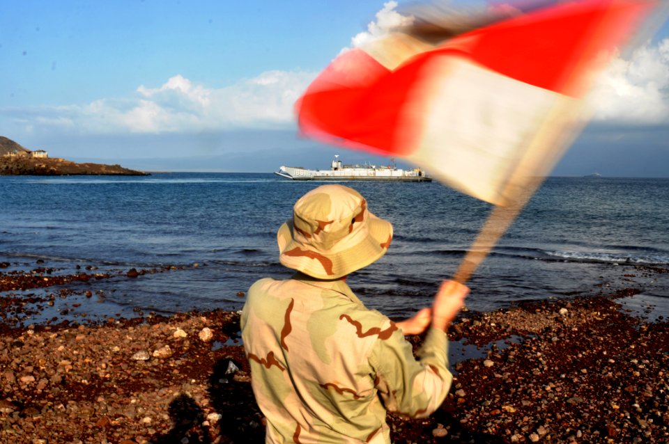 US Navy 101029-N-7293M-371 Seaman Kevin Rovito, assigned to Beachmaster Unit (BMU) 2, waves the Uniform flag to signal the location of the landing
