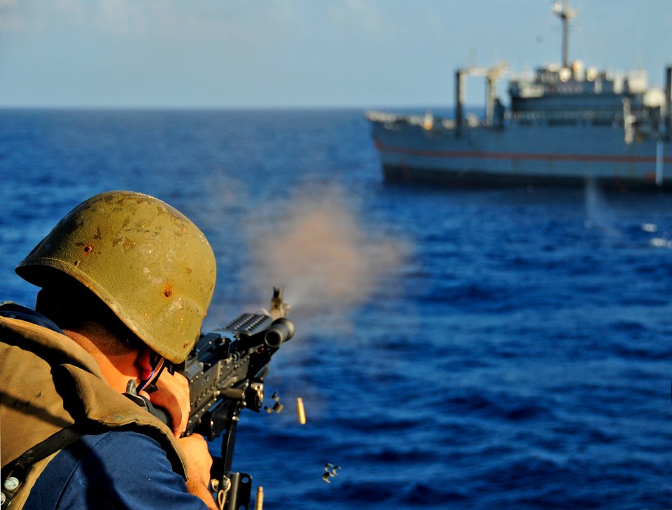 US Navy 101026-N-8913A-588 A Sailor aboard the guided-missile destroyer USS Mitscher (DDG 57) fires an M-240 machine gun at the ex-USNS Saturn duri