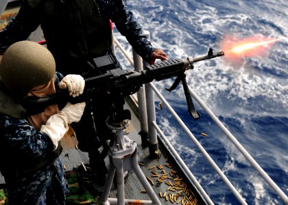 US Navy 101028-N-5538K-090 Aviation Ordnanceman Airman Nicole M. Calvery fires a M-240B machine gun during a live-fire exercise aboard the forward