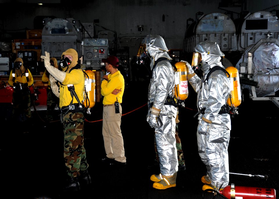 US Navy 101030-N-8721D-097 Aviation Boatswain's Mate (Handling) Airman Ronald Lewis gives instructions to hose teams as they fight a simulated fire
