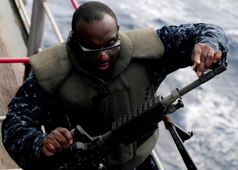 US Navy 101028-N-5538K-360 Aviation Ordnanceman 1st Class Justin L. McCray replaces the barrel of a M-240B machine gun during a live-fire exercise