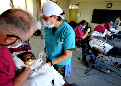 US Navy 101029-N-4153W-332 Military dentists embarked aboard the multipurpose amphibious assault ship USS Iwo Jima (LHD 7) provide dental care duri photo