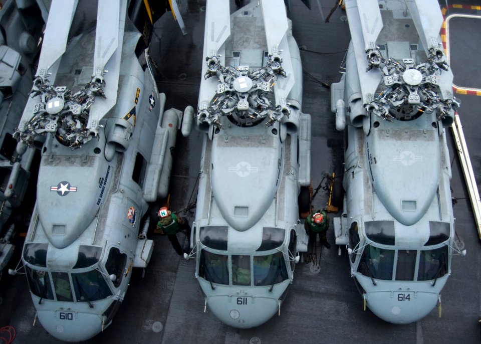 US Navy 101028-N-8721D-023 Sailors walk between helicopters on the flight deck of the aircraft carrier USS George Washington (CVN 73)