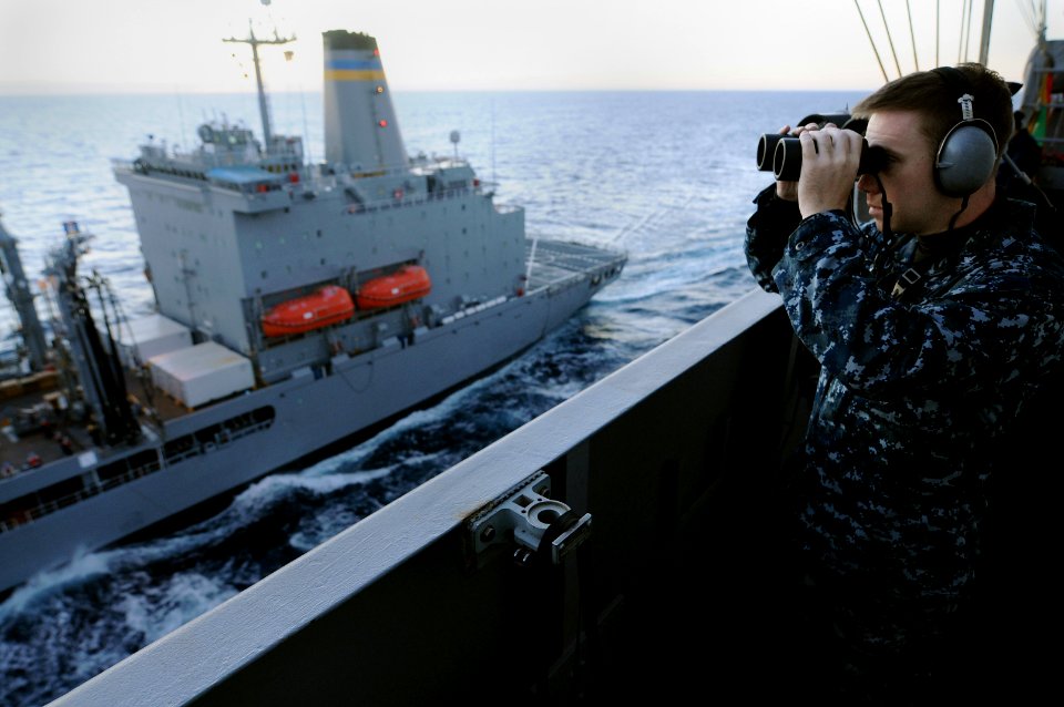 US Navy 101031-N-9132C-150 Operations Specialist 3rd Class Stephen Sittner, from Denver, stands the starboard aft lookout watch aboard the aircraft