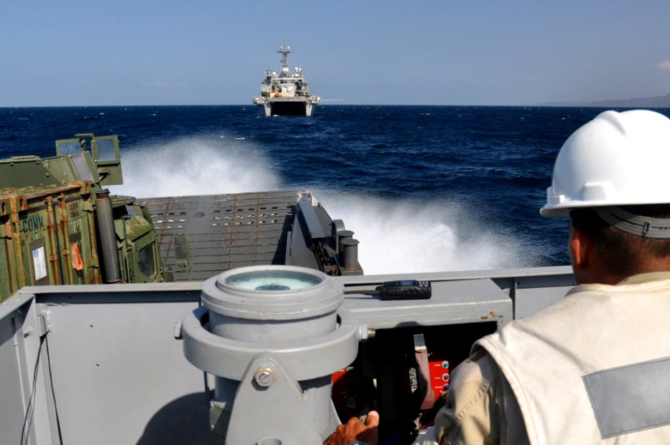 US Navy 101029-N-7293M-153 Chief Boatswain's Mate George Beck, small craft master of Landing Craft Utility 1661, pilots the craft through rough sea