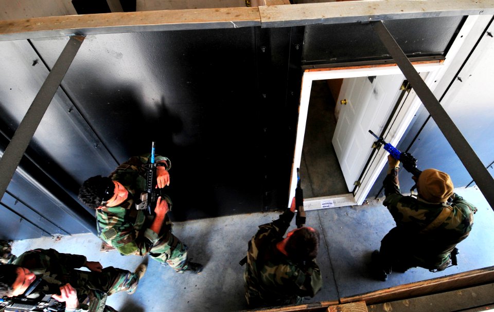 US Navy 101106-N-4044H-009 Navy SEALs enter a simulated home while practicing close quarters combat at U.S. Training Center Moyock