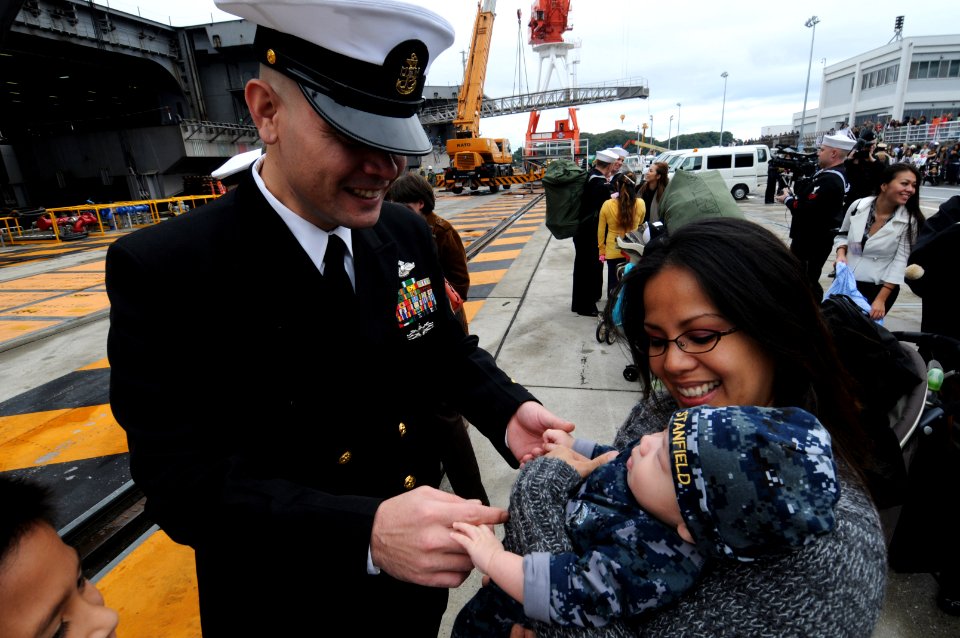 US Navy 101101-N-7191M-063 Chief Hospital Corpsman David Stanfield greets his wife and newborn son on the pier shortly after the aircraft carrier U