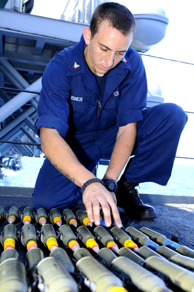 US Navy 101102-N-3154P-107 Gunner's Mate 3rd Class Marc Hibner loads blue-tipped, target practice tracer rounds for a MK-38,