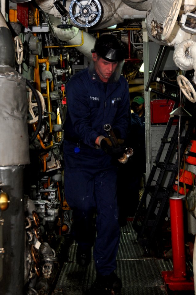 US Navy 101107-N-7293M-146 Machinist's Mate 3rd Class Shawn Stevens removes a burner barrel from the No.1 boiler aboard USS Ponce (LPD 15) during a