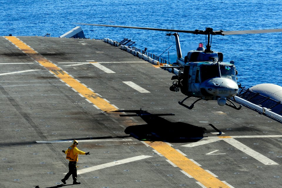 US Navy 101104-N-3659B-086 An aviation boatswain's mate (handling) gives hand signals to land an AH-1 Cobra assigned to the Evil Eyes of Marine Med
